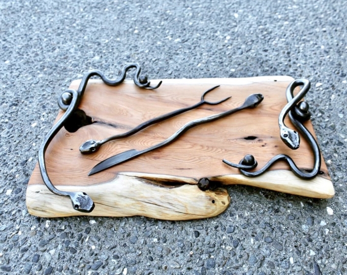 Yew serving board with snake motif handles, knife and fork